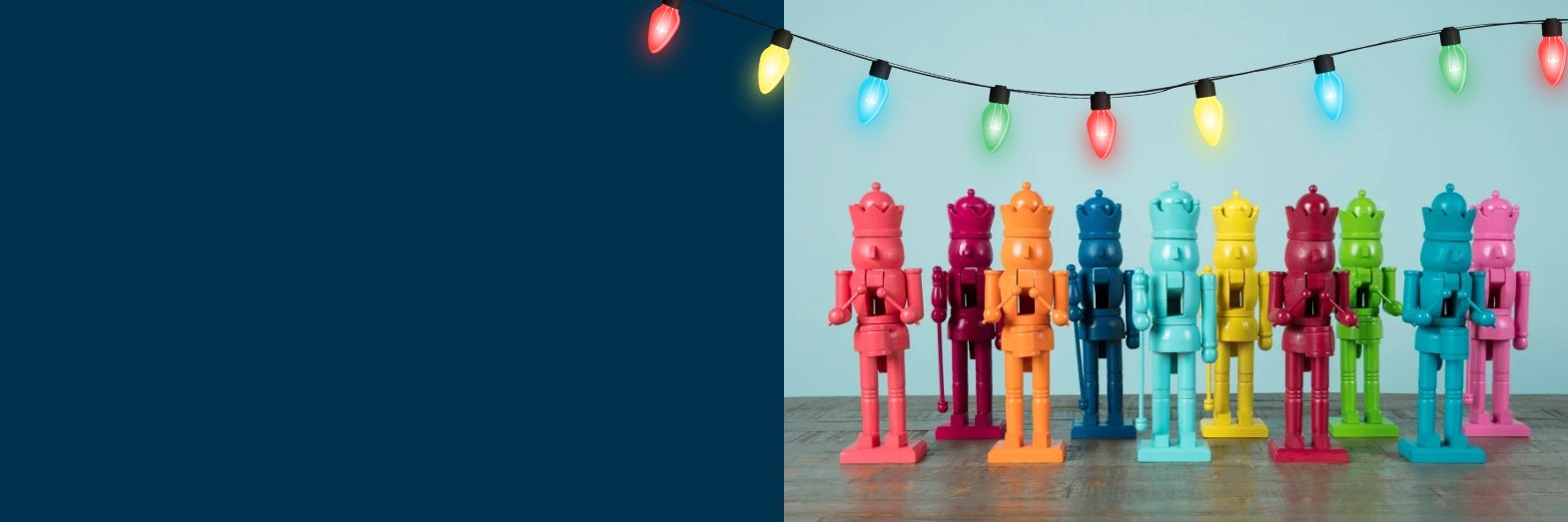 Colorful nutcrackers arranged in a row with string lights in the background.
