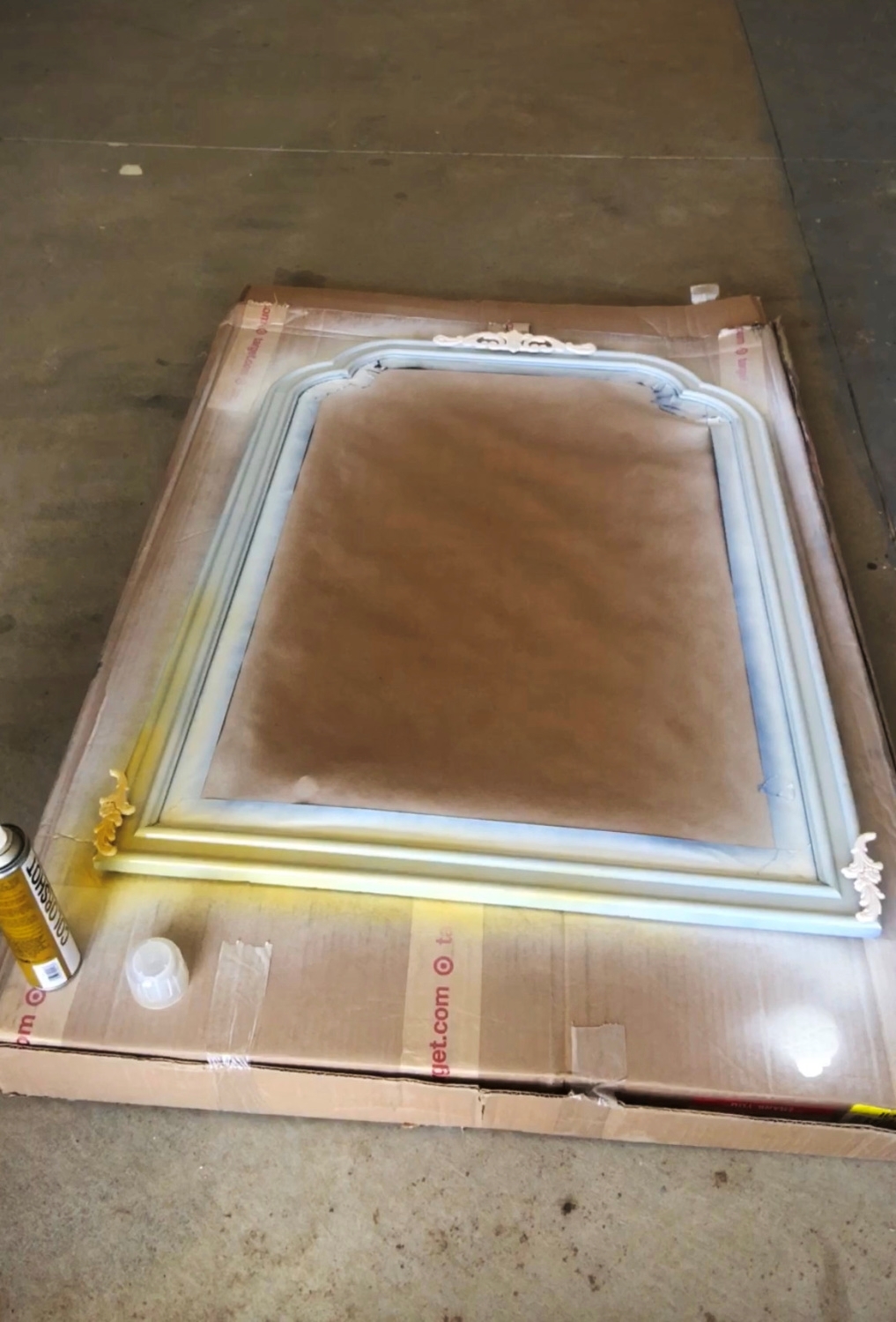 Spray paint the mirror’s frame using several light coats.