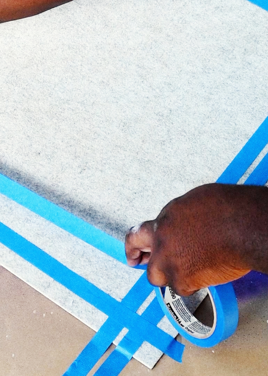 Apply painter’s tape to the edges of doormat