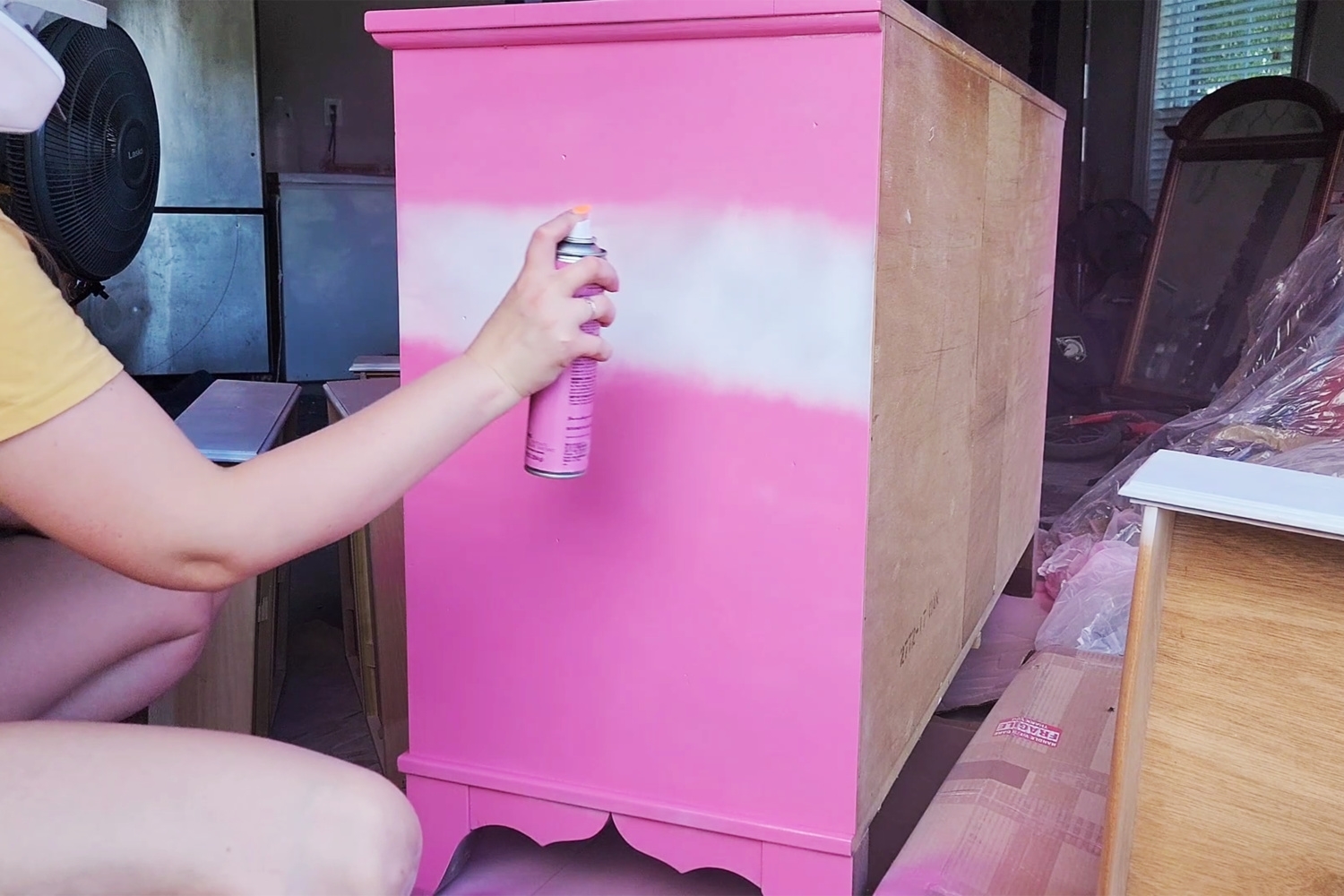 Apply pink spray paint to the dresser