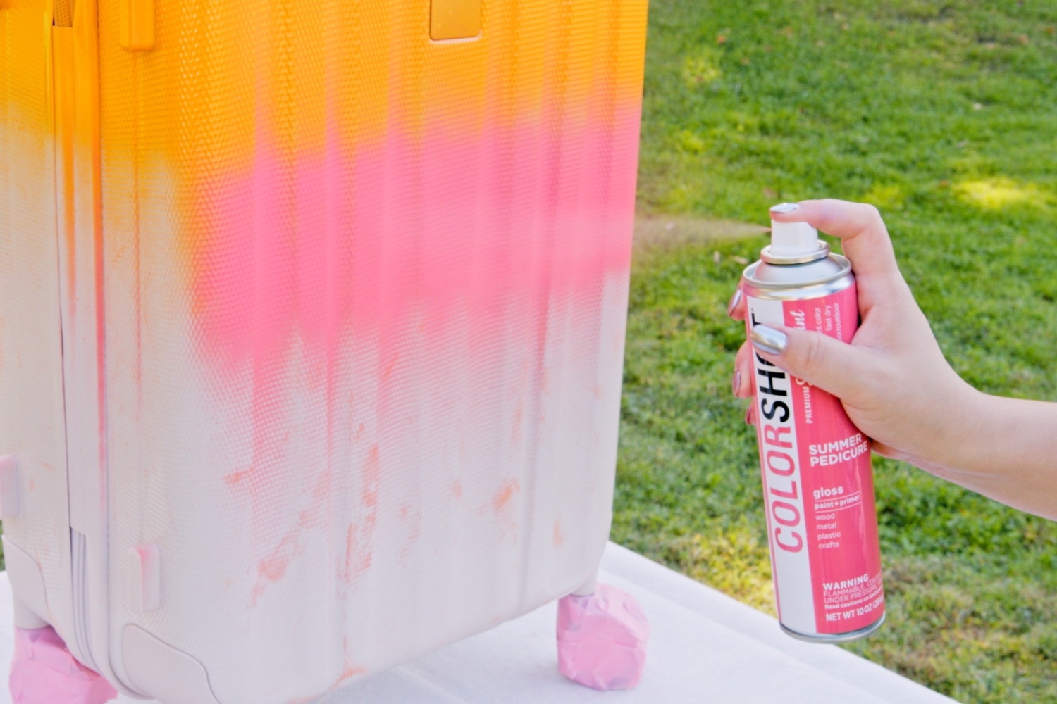 Apply the next color of spray paint to the suitcase